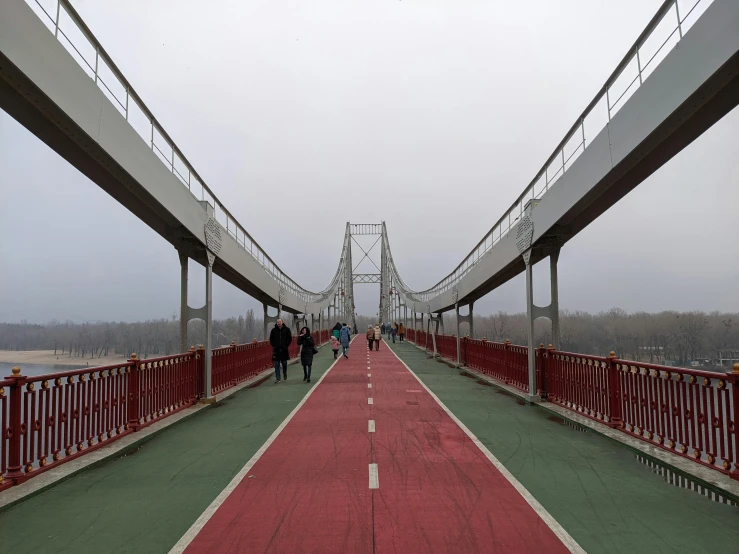 a red bridge going across it with people walking on top