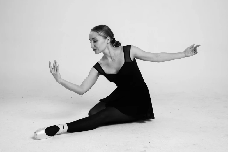 a woman in black dress stretching on one leg