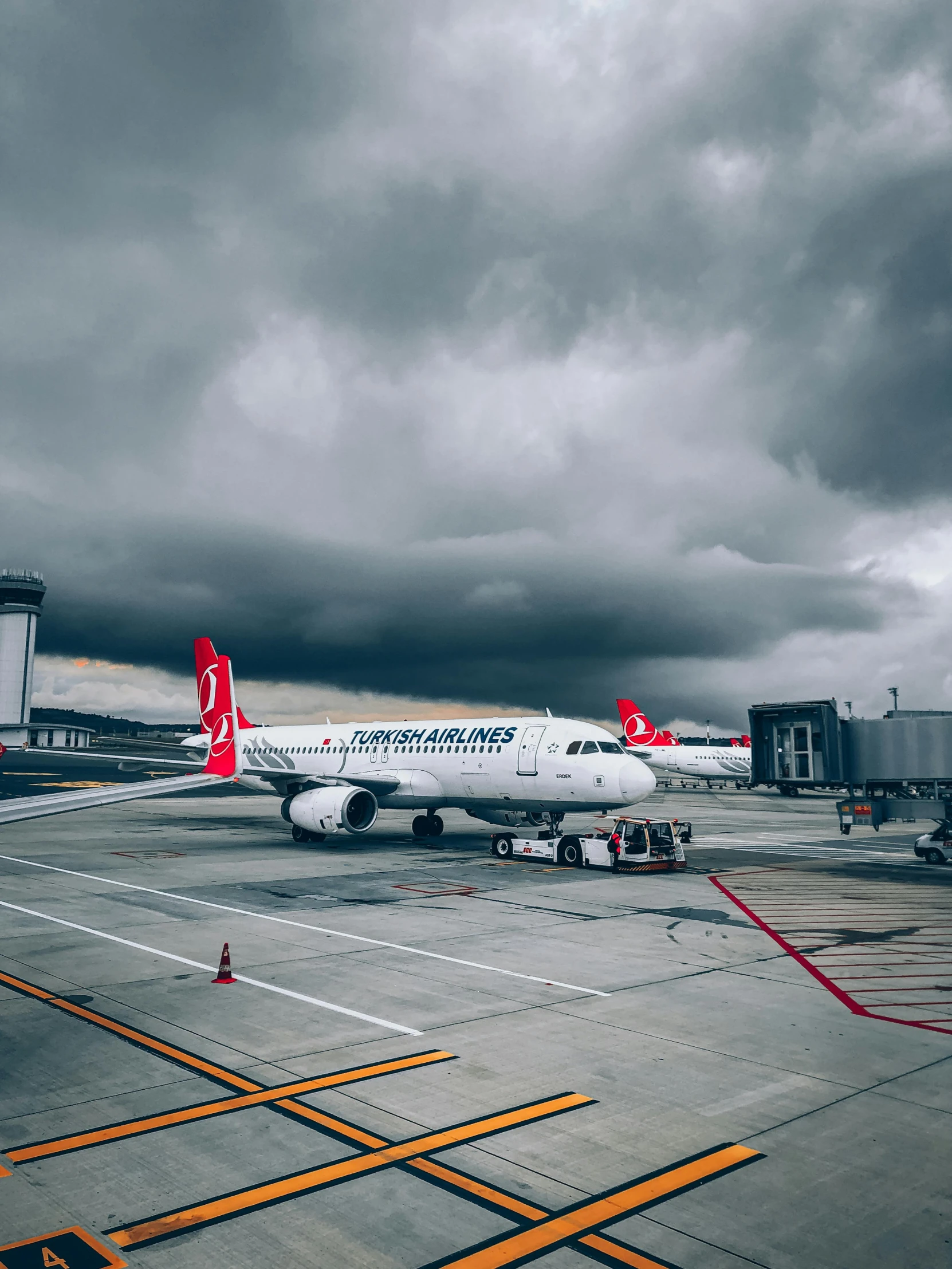 a big airplane on the tarmac by some vehicles