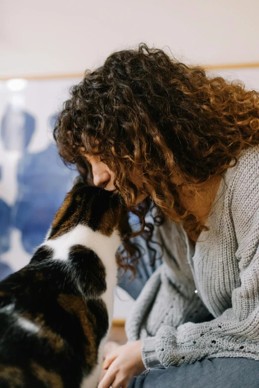 a woman kneeling down petting a dog