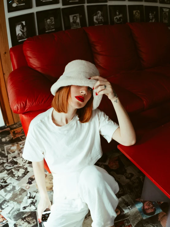red headed woman sitting in a room wearing white
