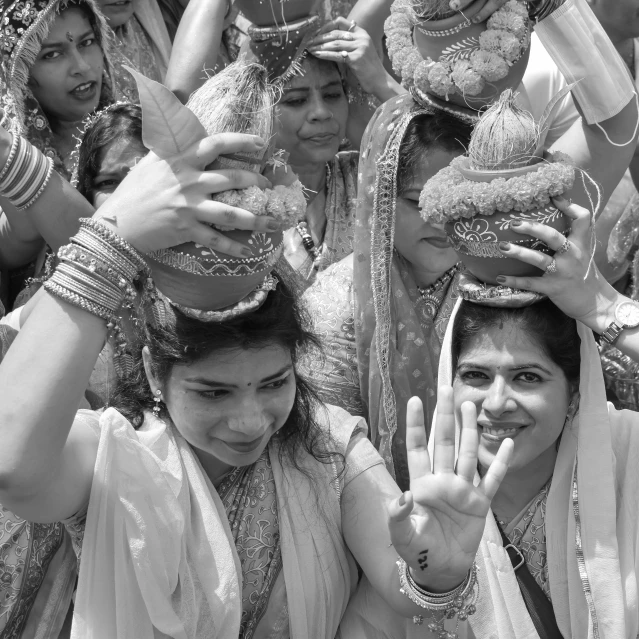 a group of women in indian garb doing a peace sign