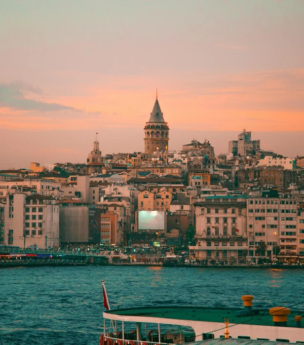 a river view of buildings, a boat, and a clock tower