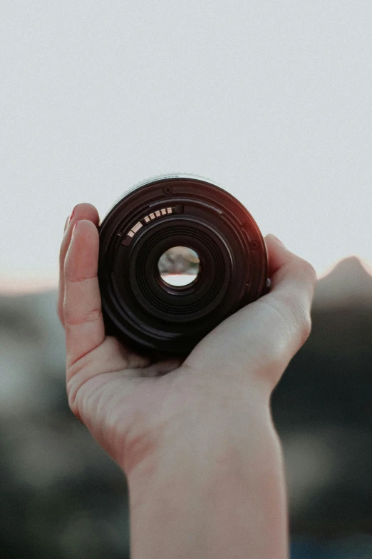 someone holding up a lens in their hand