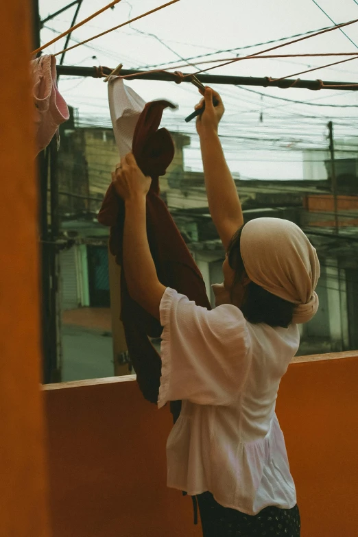 a person on a roof fixing clothes on a line