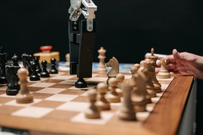 the toy robot is standing on top of the chess board