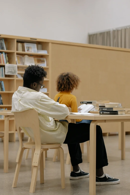 a child sits at a table in front of an adult