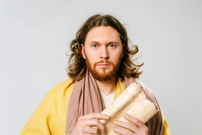 a man with long hair holding a piece of bread