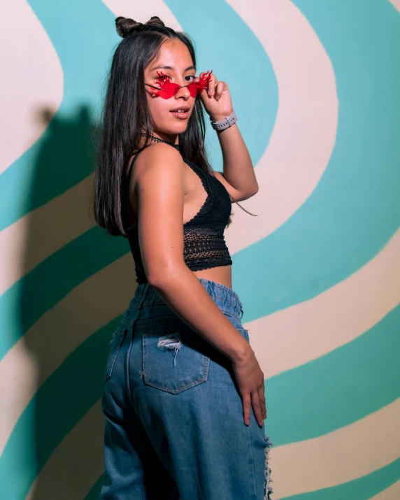 a young woman poses in front of a mural