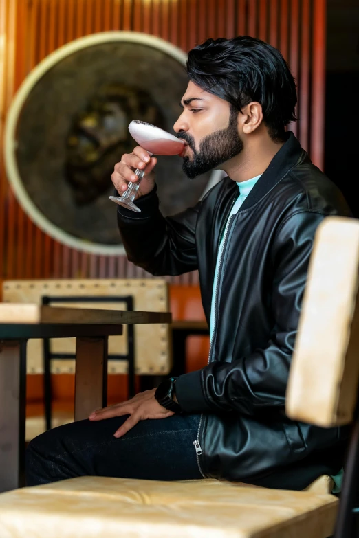 man holding an electric hair dryer while sitting on a chair