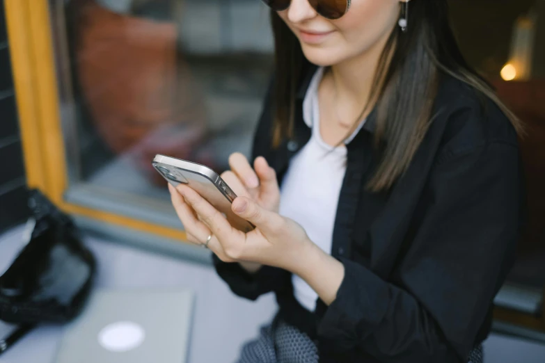 a woman in sunglasses looks at her cellphone