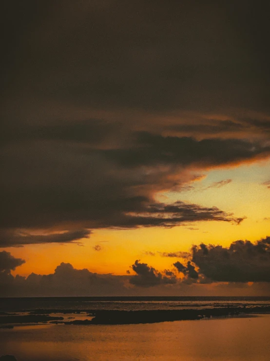 orange sky with some dark clouds above it