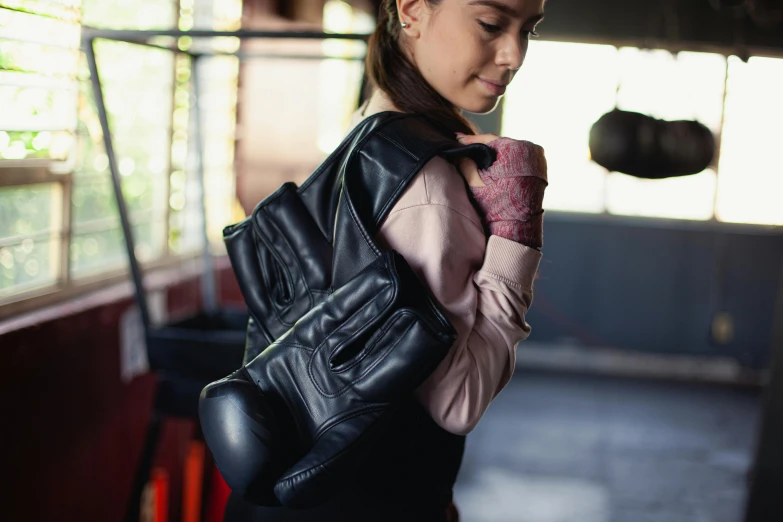 woman in pink shirt holding purse with black material