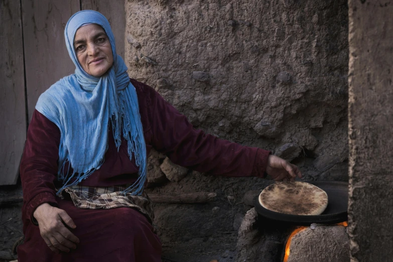 a woman that is sitting in front of a stove