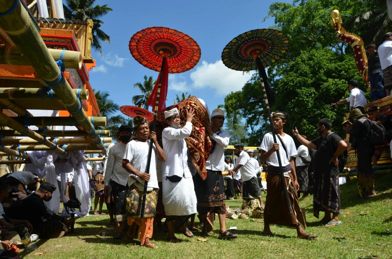 people in white outfits carry umbrellas down the hill