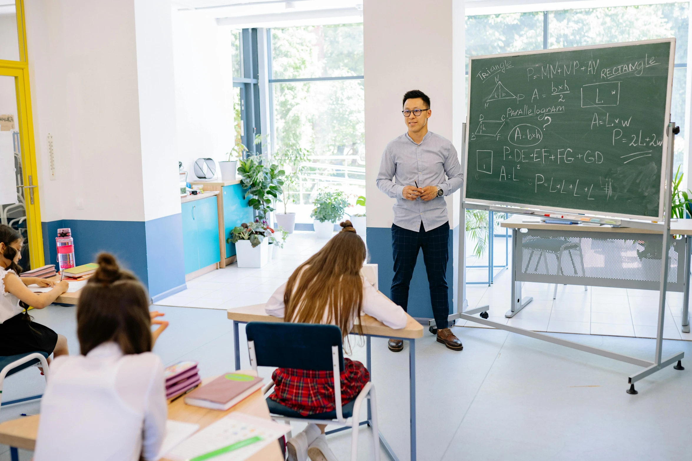 a man is standing next to a chalkboard while others watch