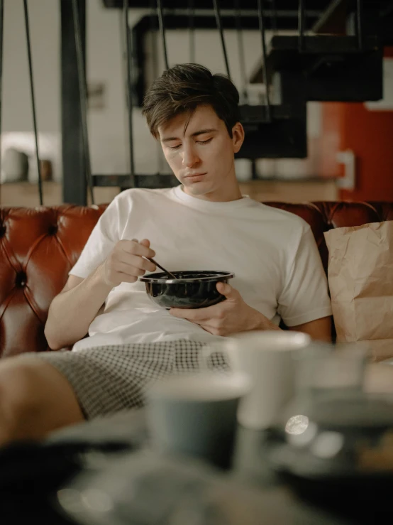 a man sits with his hands near his heart eating