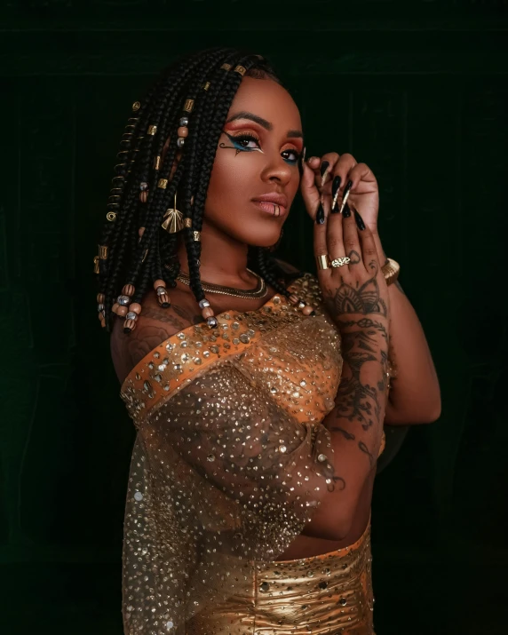 an african american woman in a gold dress with dreadlocks and tattoos