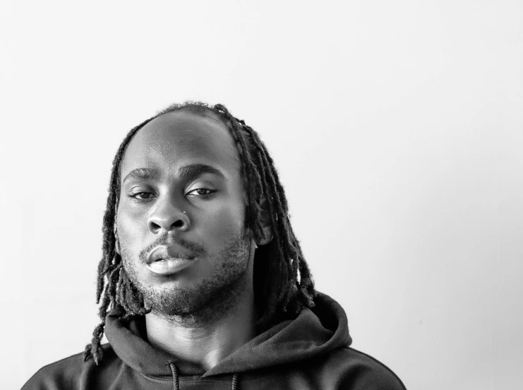 a man with dreadlocks on his face and black hoodie