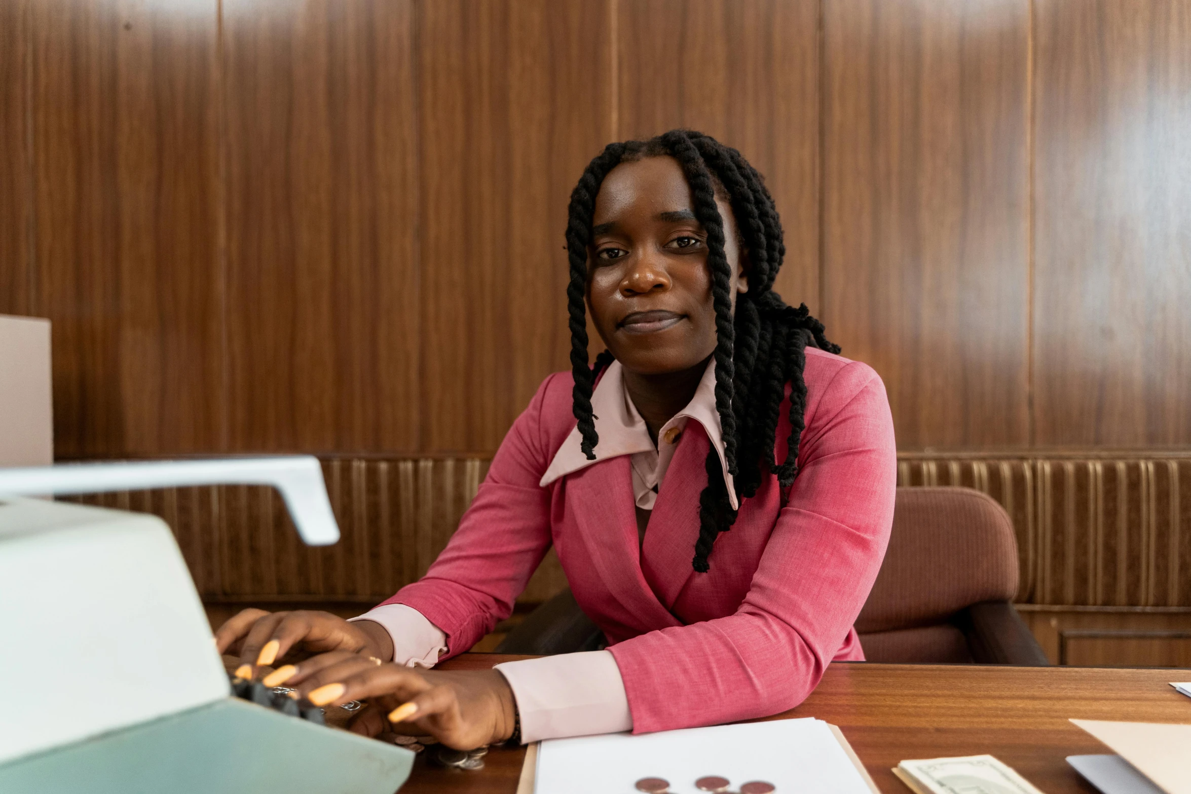 a black woman sitting at her desk with a laptop