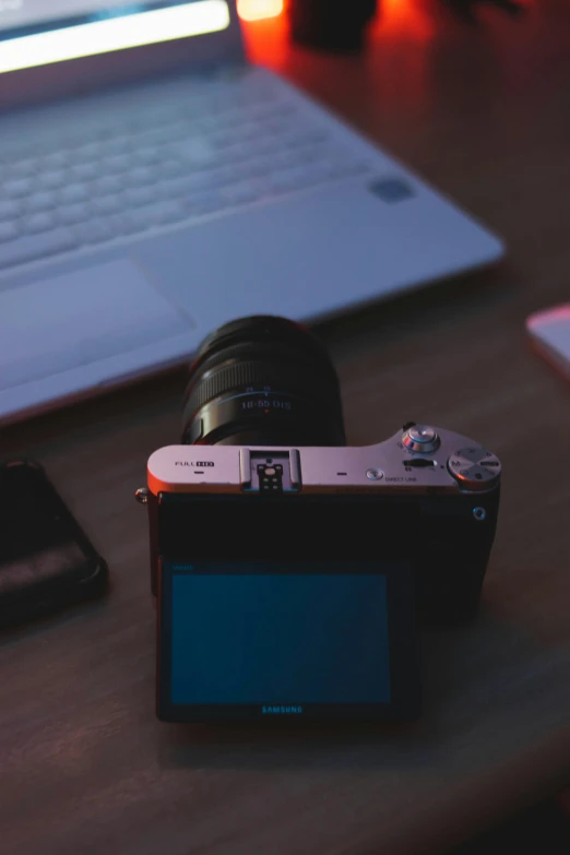 a camera and a cell phone sitting on a desk