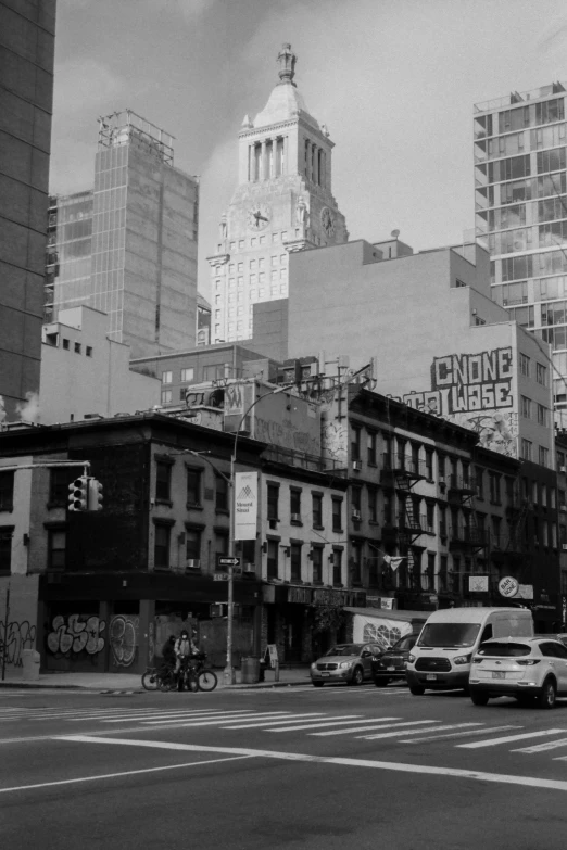 a city intersection with buildings and cars driving by