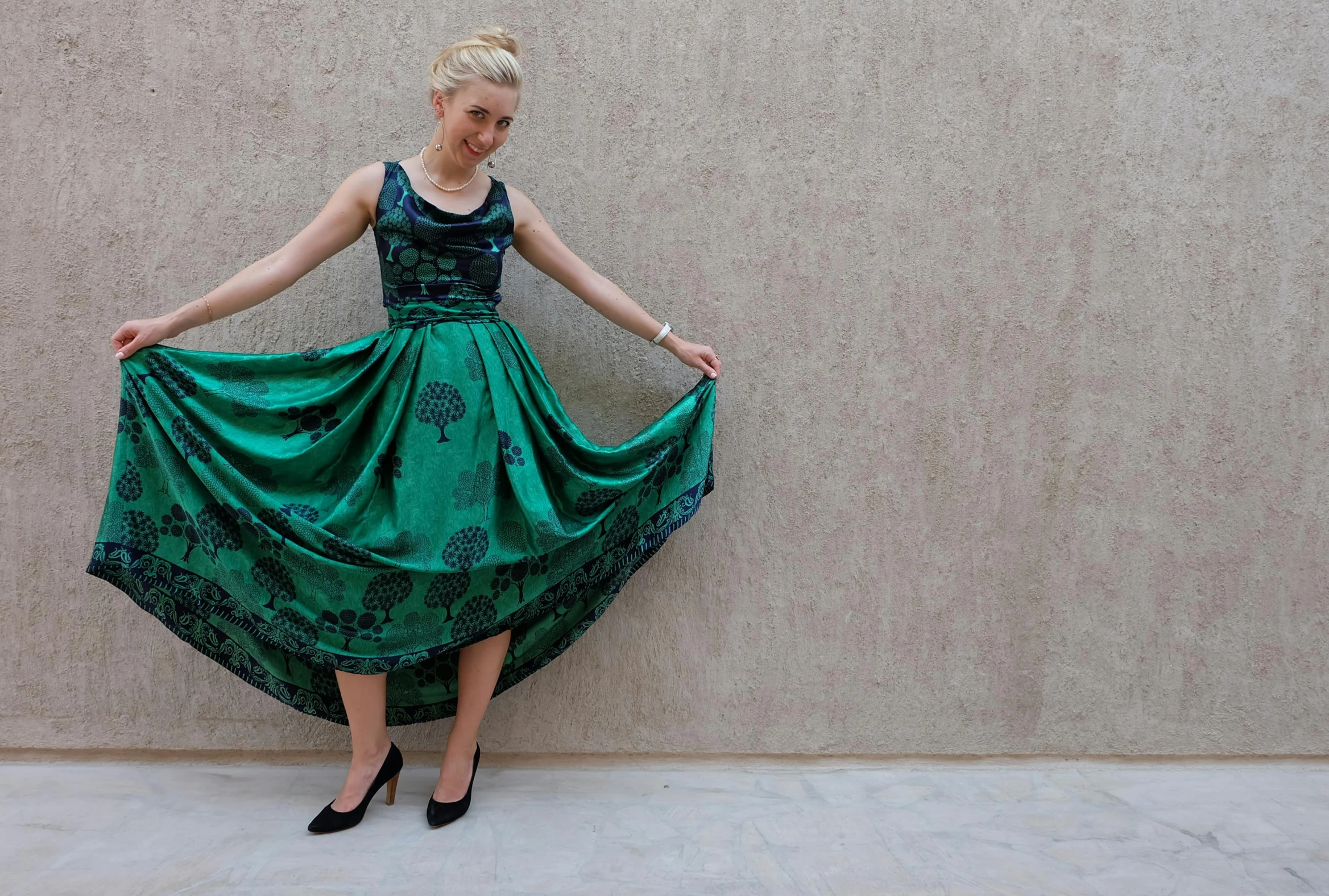 the woman is standing near a concrete wall