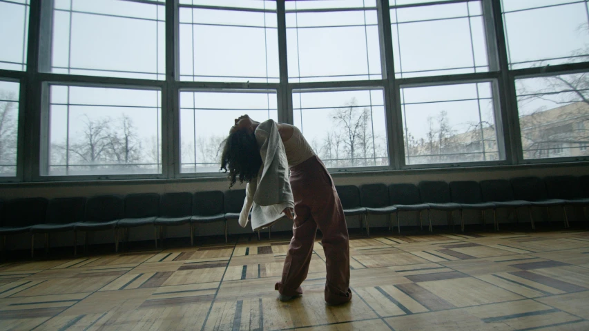 a woman with a white umbrella standing in an empty room