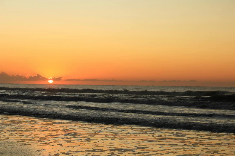 a person walking in the water on a beach