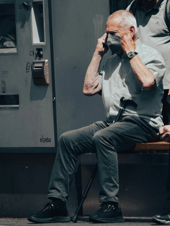 an old man sitting on a bench with his head in his hands