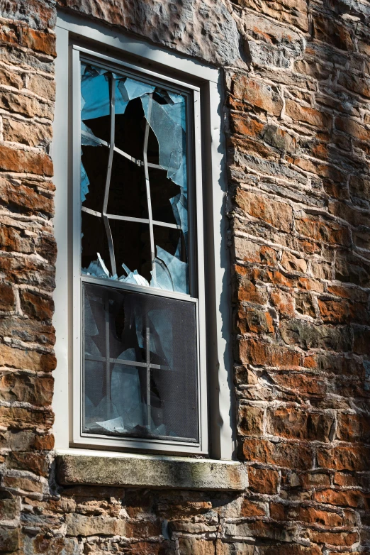 a broken window in an old brick building