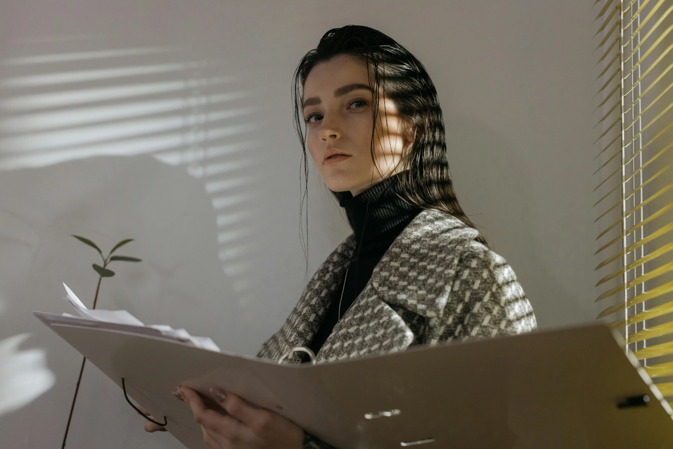 woman with curly hair reading a piece of paper