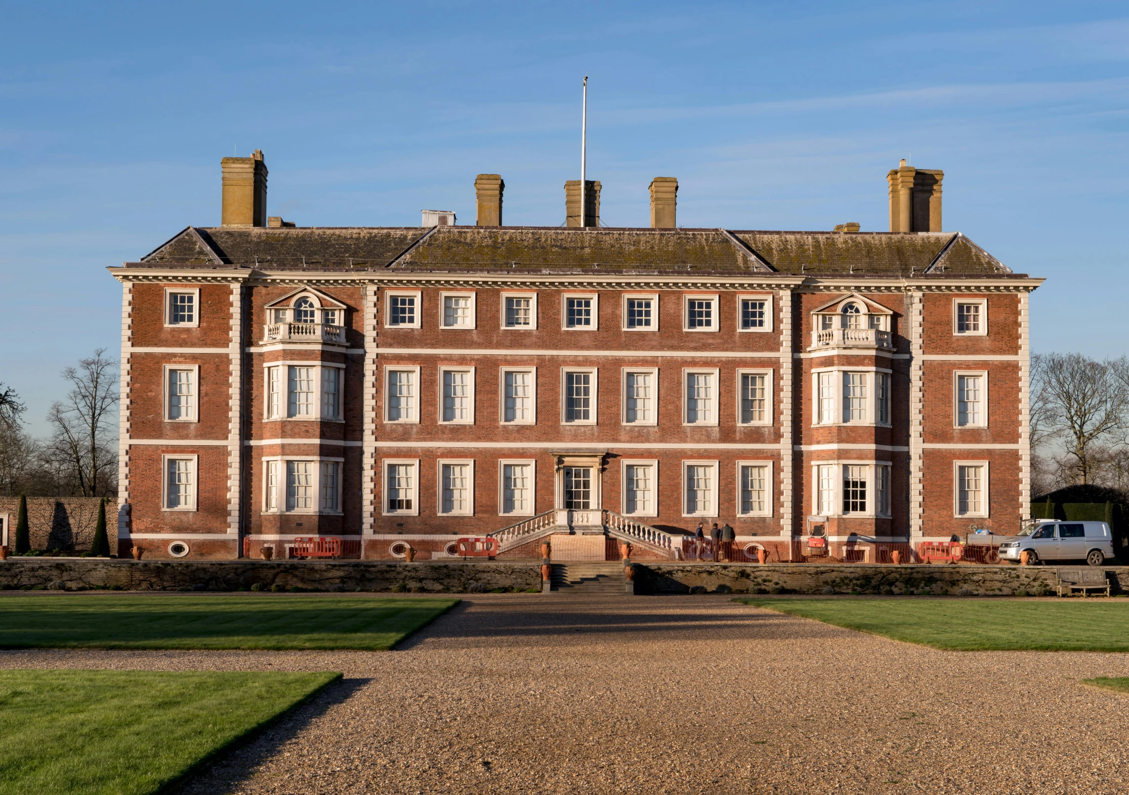 a large brick building sitting on top of a grass covered field