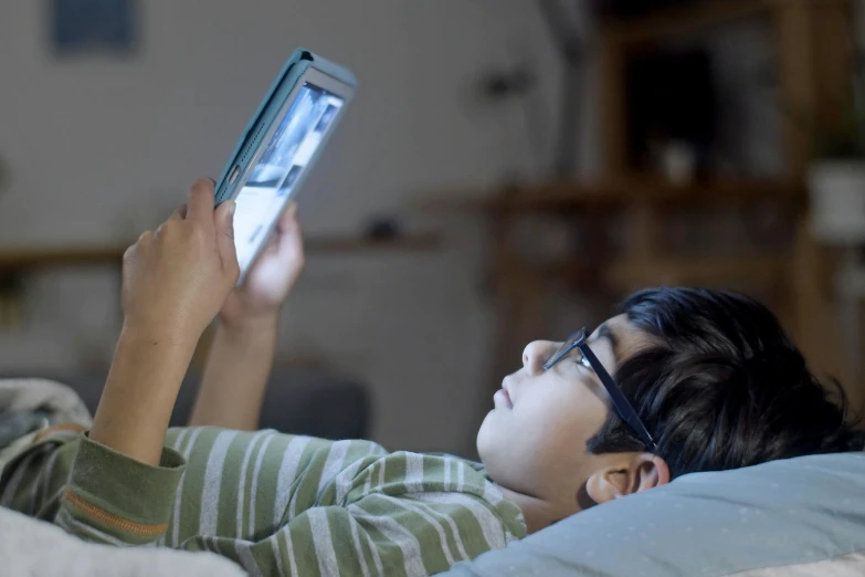 a  laying on the couch with an electronic device