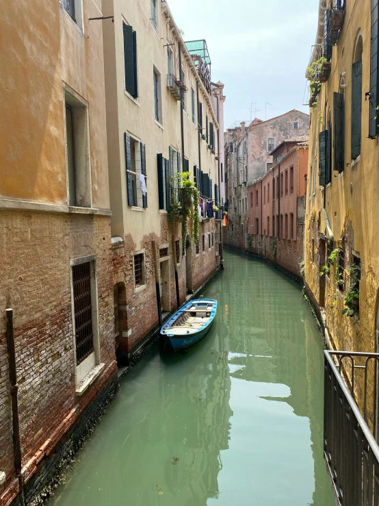 a small boat is floating along an canal