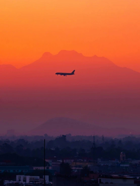 a plane is flying in the air over some buildings