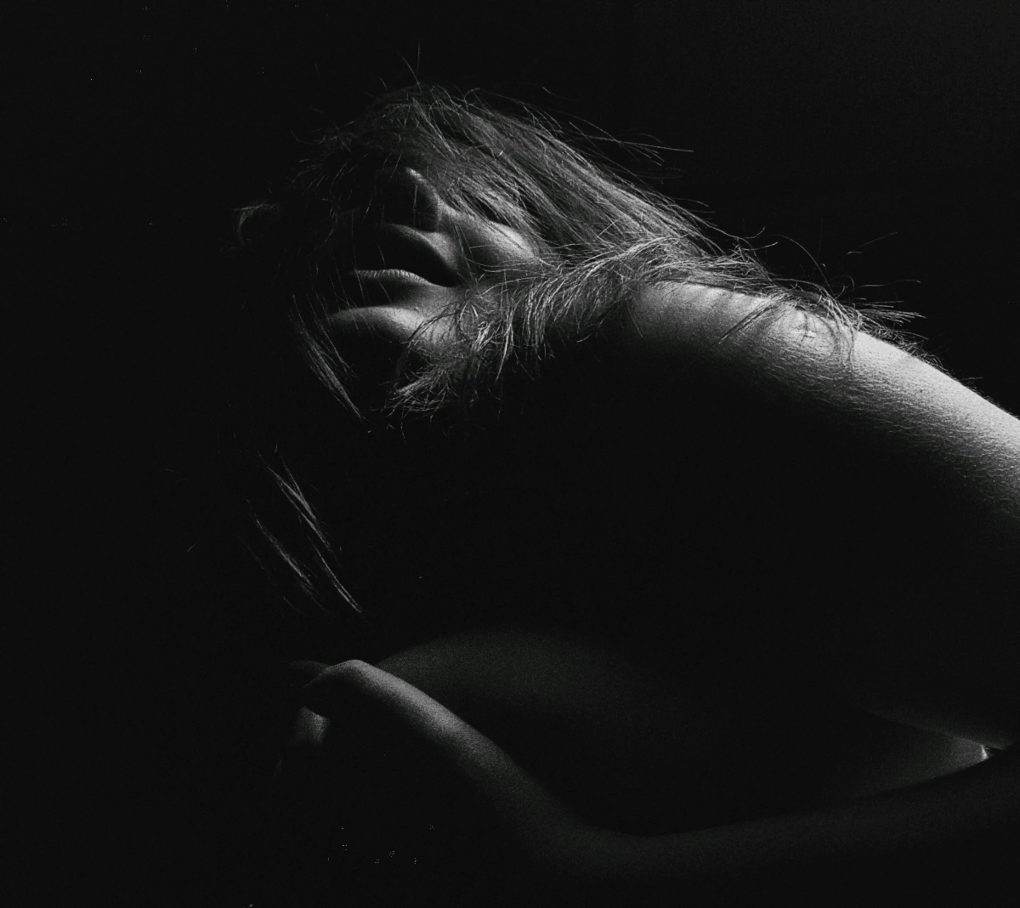 a woman is hiding her face in the darkness