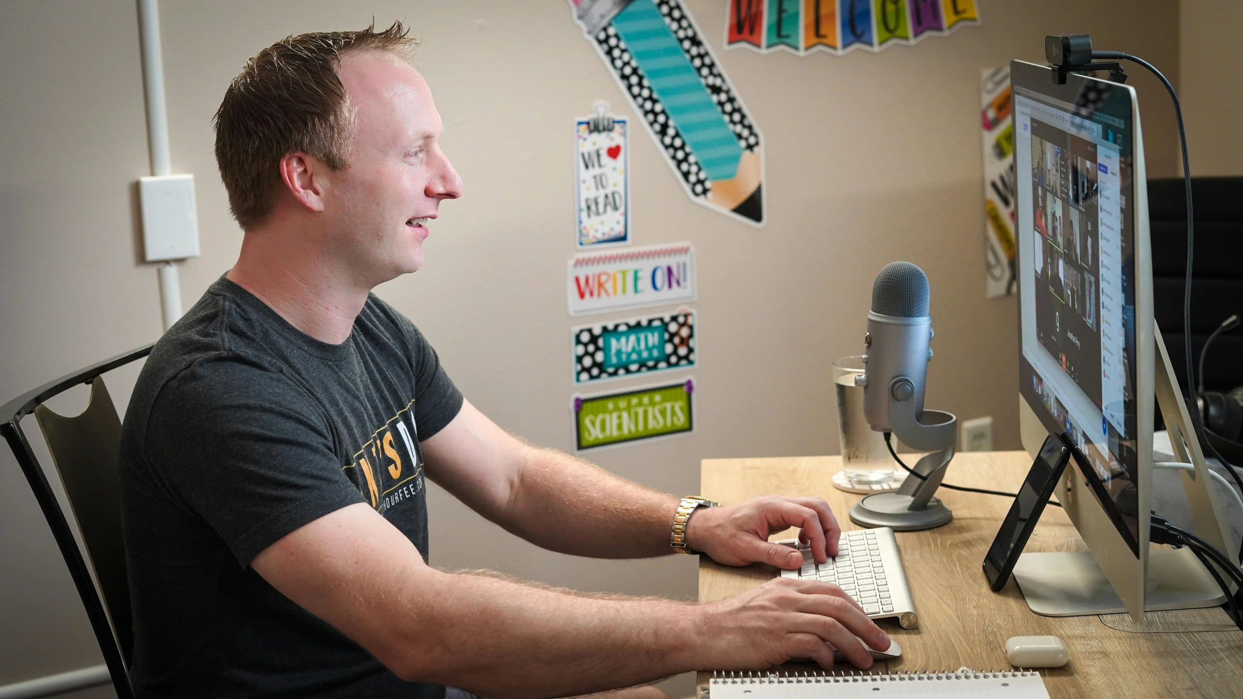 man at a desk using a computer while listening to music