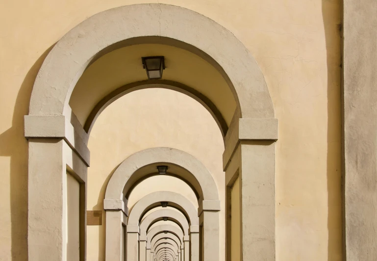 a narrow walkway with arches over the road