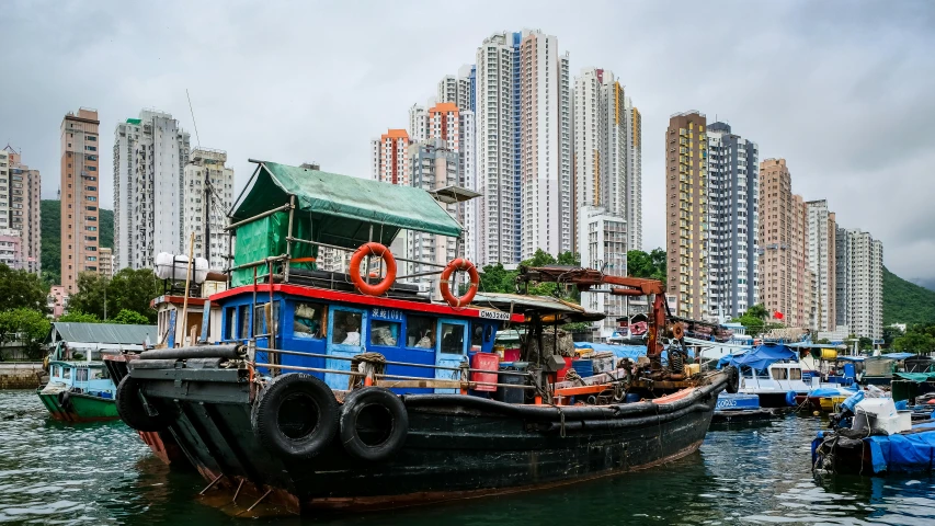 a colorful boat sitting on the side of a river next to buildings