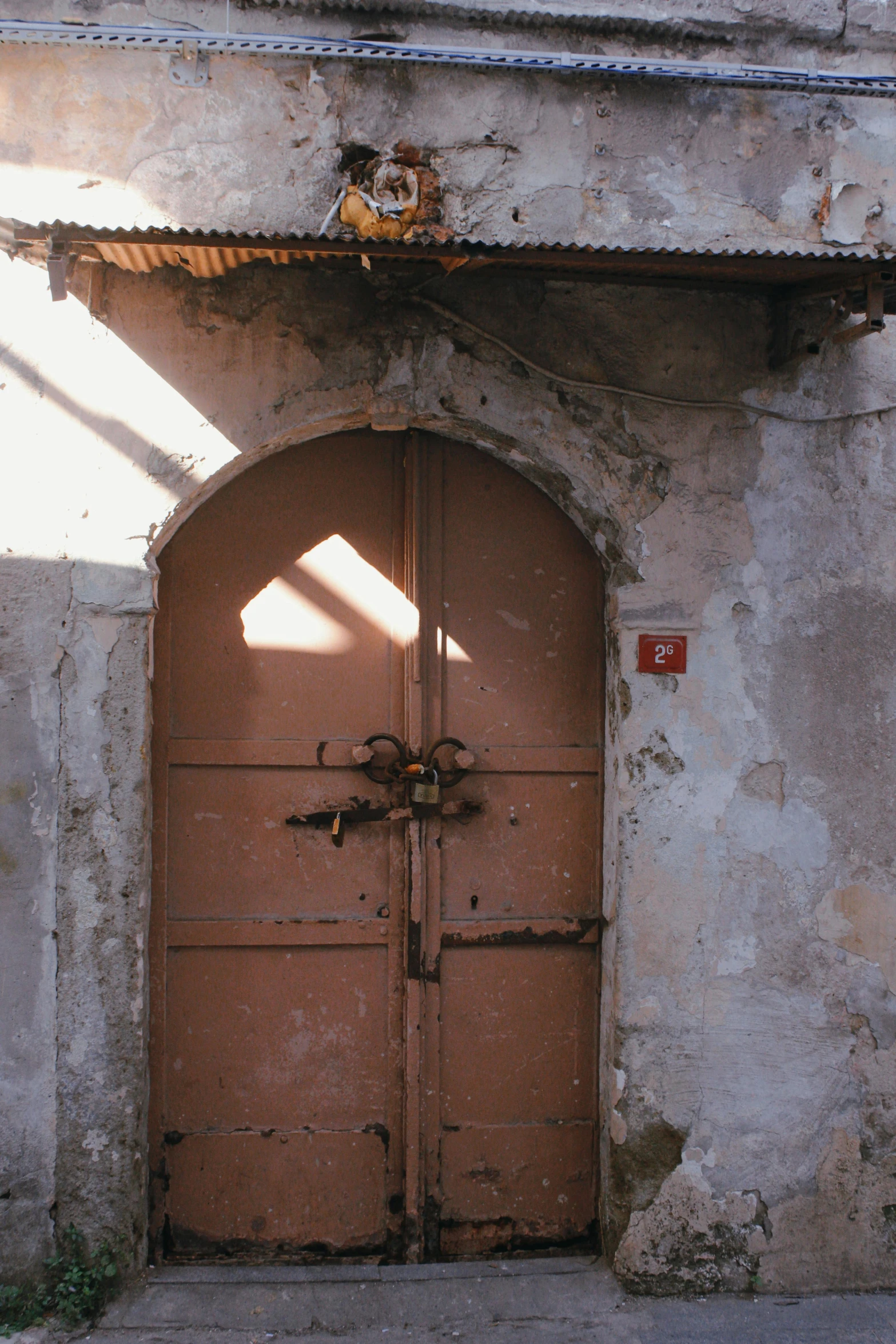 a building with an arched door and brown trim