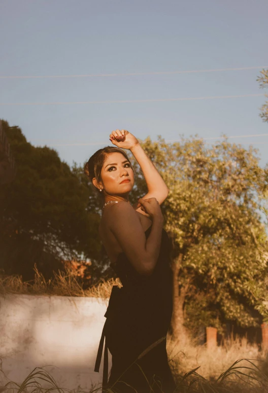 a woman in a long black dress poses for the camera