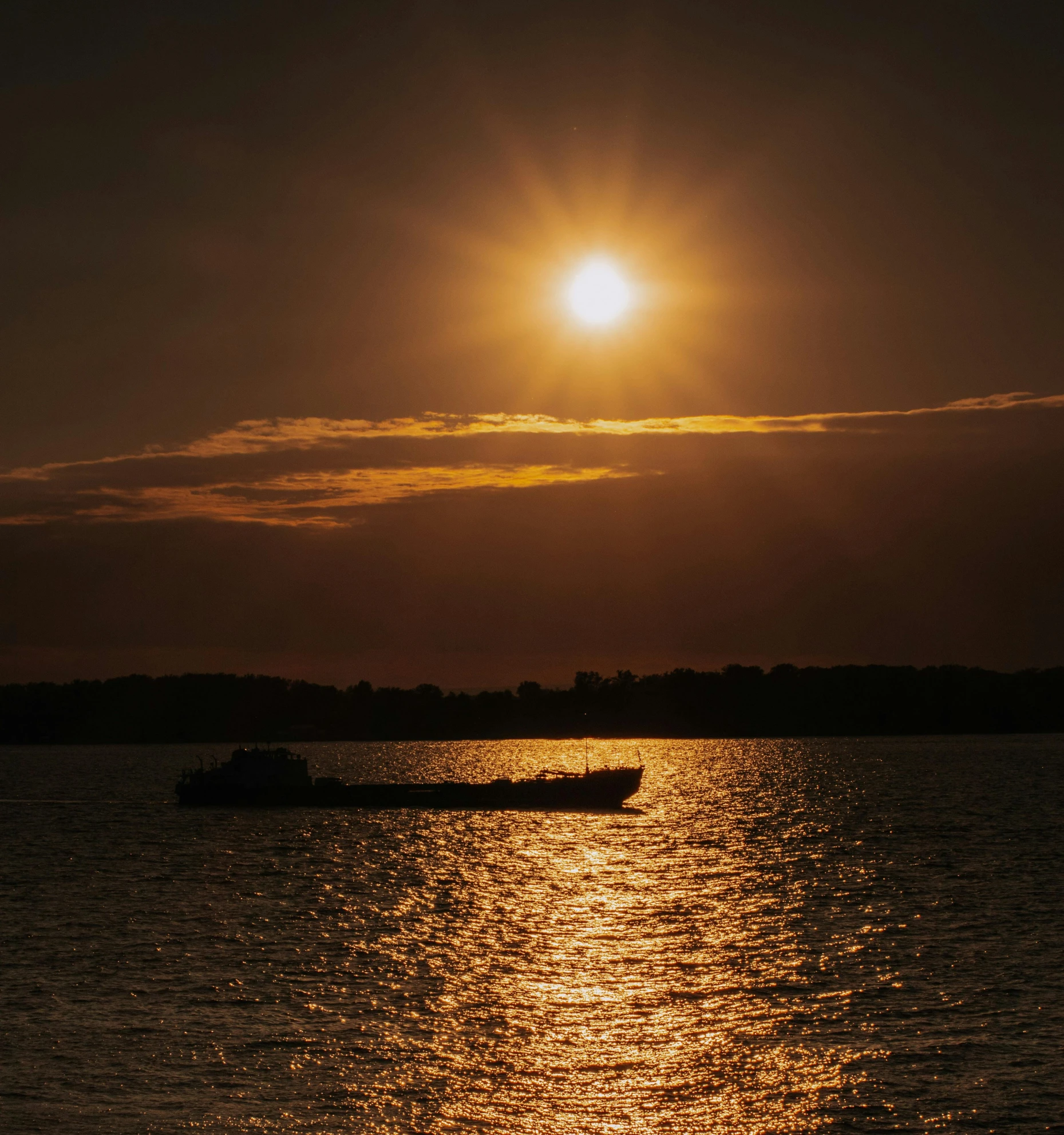 a boat sitting in a body of water at sunset