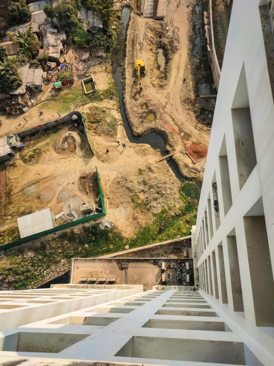 the view from the top of an up - stairs shows dirt and construction work