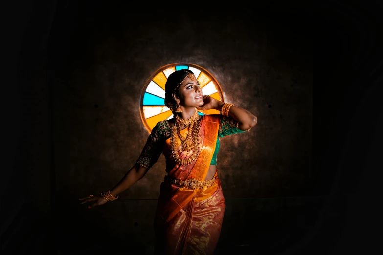 a woman with a yellow dress and jewelry stands in front of a fan