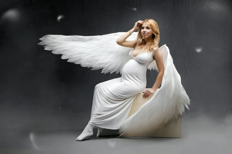 a woman wearing a dress is sitting down and angels are around her