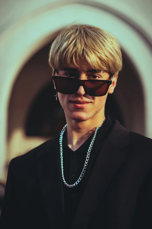 young man with sunglasses looking down at camera