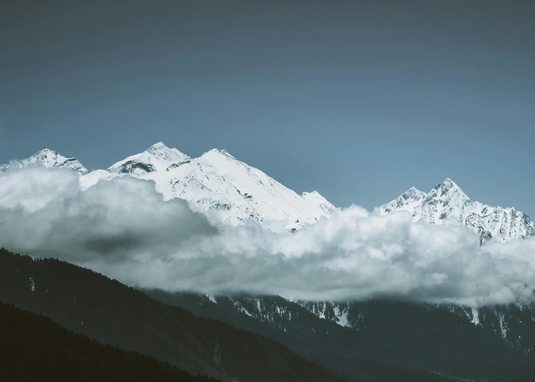 a mountain range with clouds and snow in it