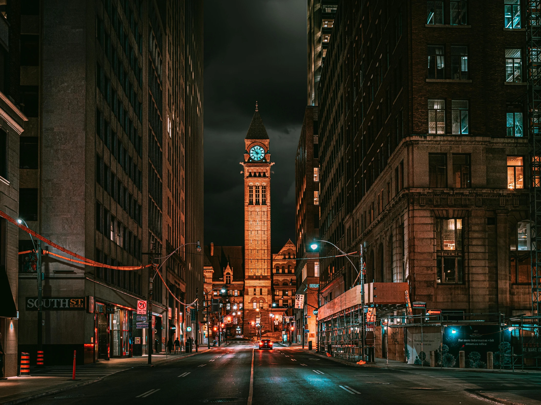 night in an urban area with tall buildings and lights on