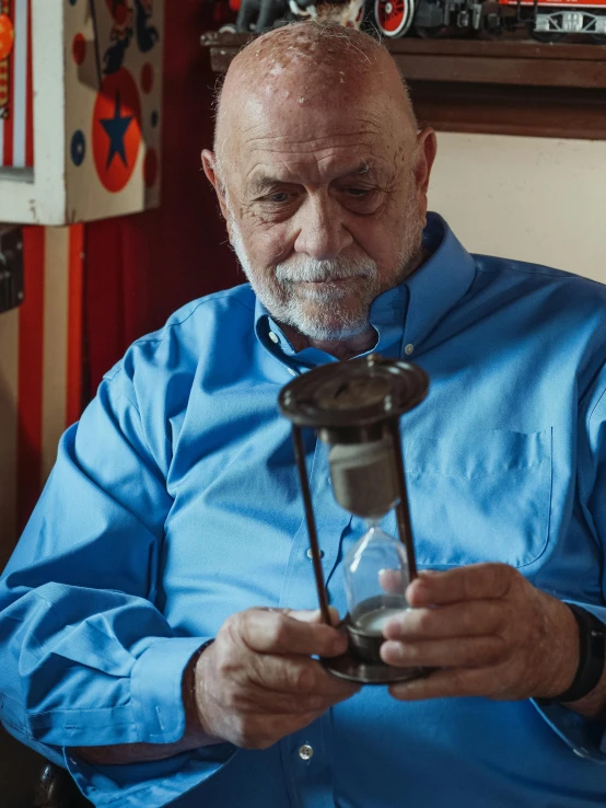 a man with a grey beard is looking at his phone